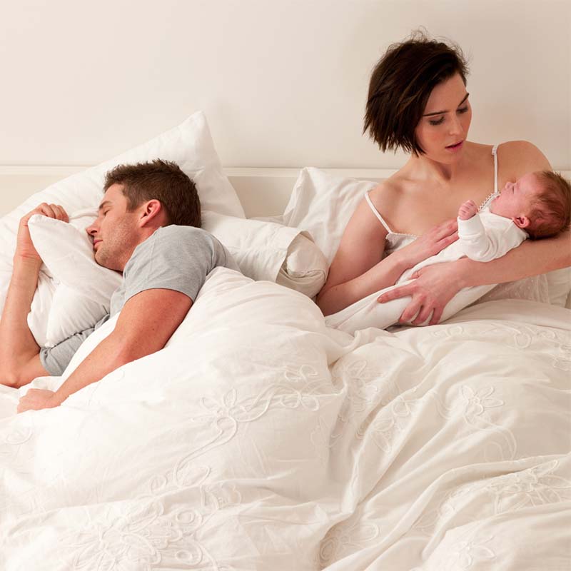 Parents in bed with early rising baby