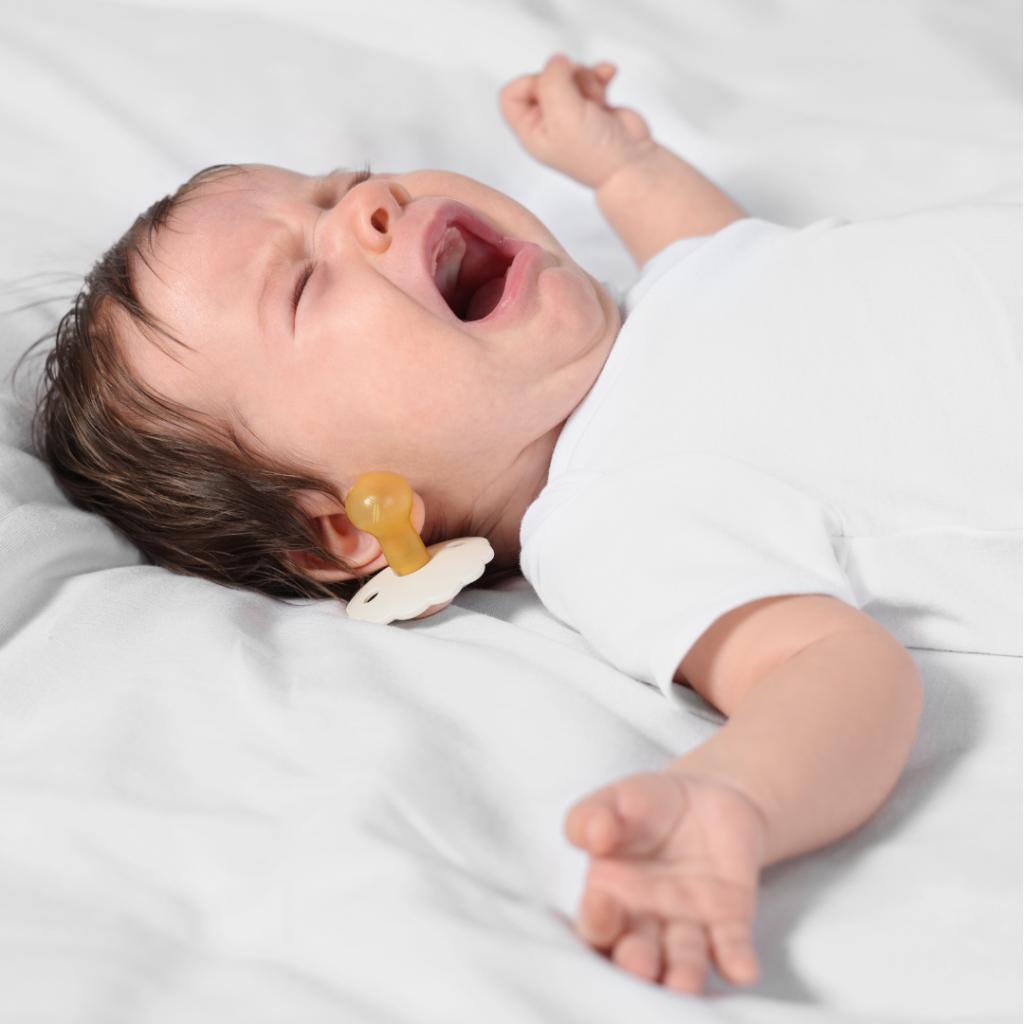 Baby who is crying because their dummy has fallen out