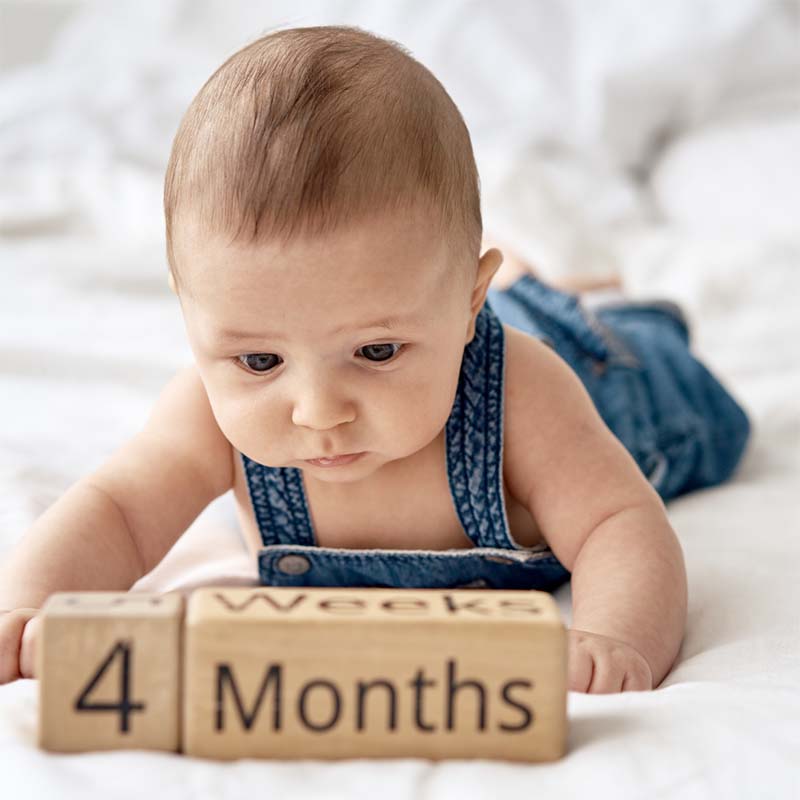 Baby with 4 month old blocks in front