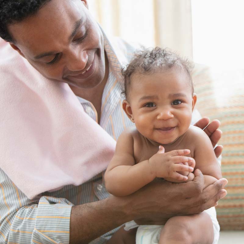 Happy dad burping a happy baby