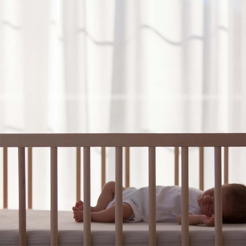 Baby sleeping peacefully in cot